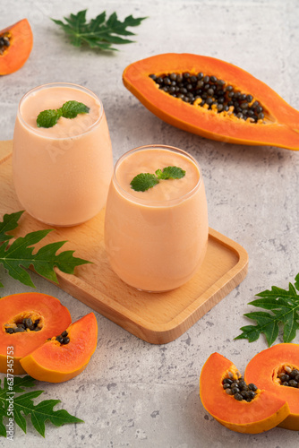Delicious papaya milk smoothie in glass cup on gray table background