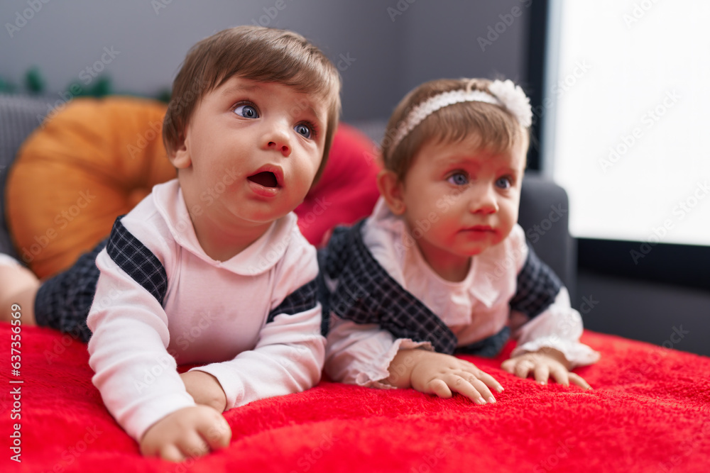 Two adorable babies lying on sofa at home Two adorable babies lying on sofa at home