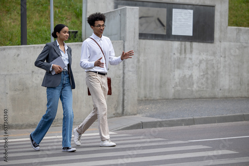 Young couple talking and crossing the street