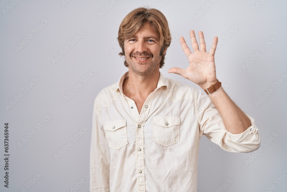 Middle age man standing over isolated background showing and pointing up with fingers number five while smiling confident and happy. Middle age man standing over isolated background showing and pointing up with fingers number five while smiling confident and happy.