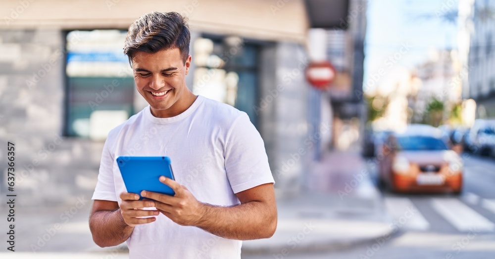 Young hispanic man smiling confident using touchpad at street Young hispanic man smiling confident using touchpad at street