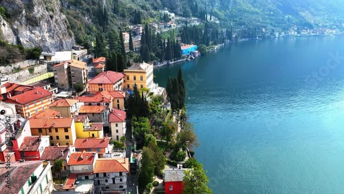 Aerial Forward Panning Shot Of Houses In Town Near Lake And Mountains On Sunny Day - Varenna, Italy photo