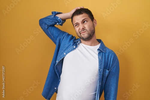 Bilde på lerret Hispanic man standing over yellow background confuse and wondering about question