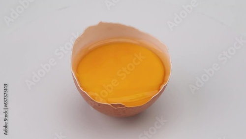 Wallpaper Mural Broken egg in half eggshell is turning on white background. close up of egg yolk in eggshell Torontodigital.ca