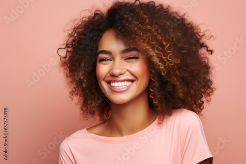 Beautiful woman with afro hair smiling on bright pink background  smiling portrait