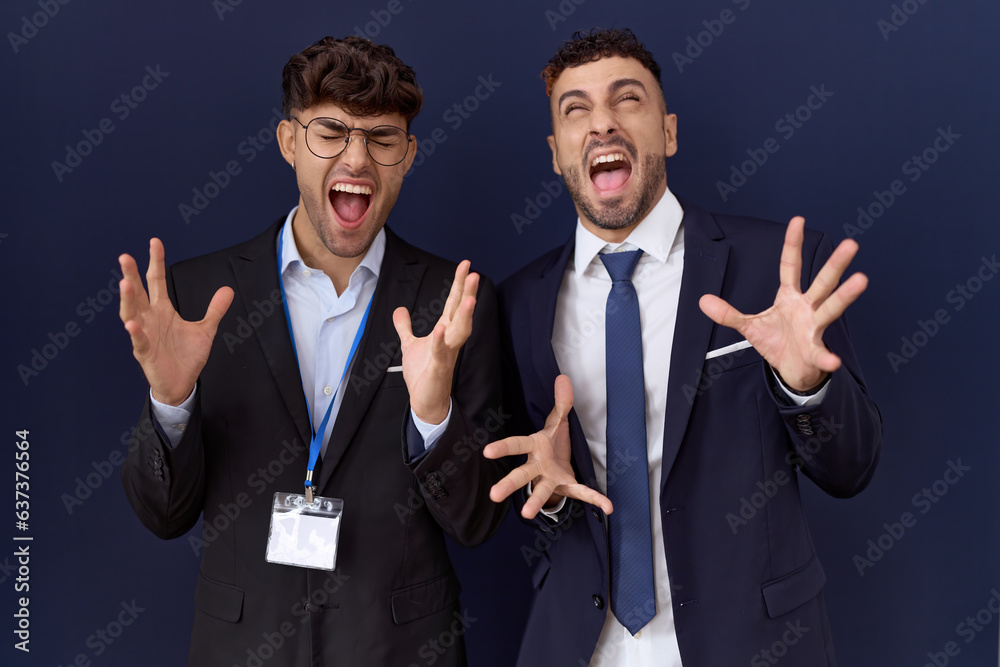 Φωτογραφία Two hispanic business men wearing business clothes celebrating mad and crazy for success with arms raised and closed eyes screaming excited