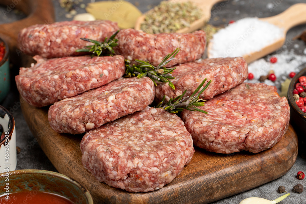 Raw beef patties. Fresh raw beef meatballs on dark background. Butcher products. Close up