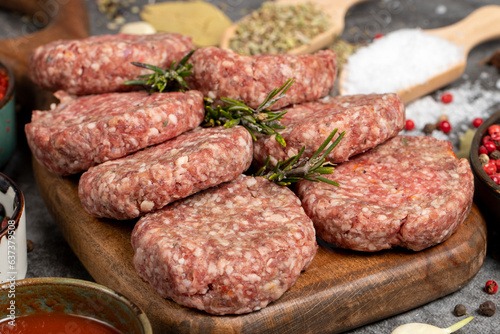 Raw beef patties. Fresh raw beef meatballs on dark background. Butcher products. Close up