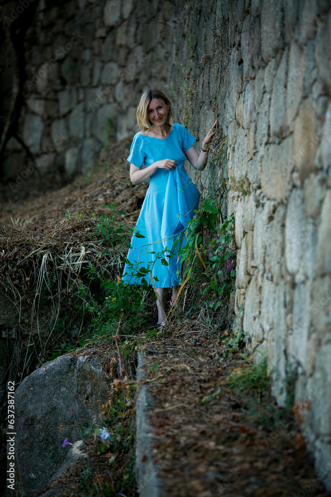 A woman in a blue dress wanders among medieval ruins. A woman in a blue dress wanders among medieval ruins.