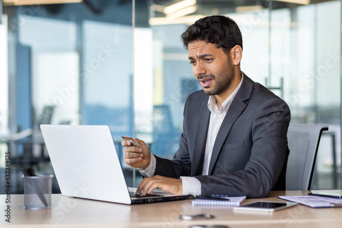 Φωτογραφία Cheated and unsatisfied disappointed businessman with bank credit card and laptop inside office, man received error, and rejected online money transfer at workplace