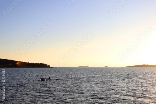 Small fishing boat on the beach in Primosten, Croatia, illuminated by warm sunset light.