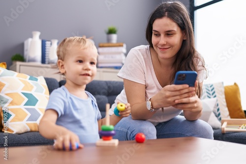 Mother and son using smartphone and playing at home
