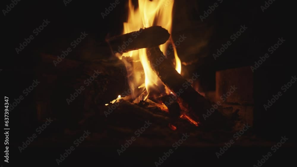 Log fire burning at night time, flames glowing with embers on a coal fire, campfire, bonfire