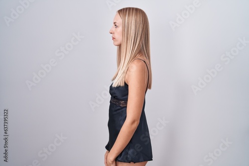 Young caucasian woman wearing nightgown looking to side, relax profile pose with natural face and confident smile. photo
