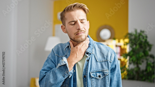 Young caucasian man being sick suffering for throat pain at home photo