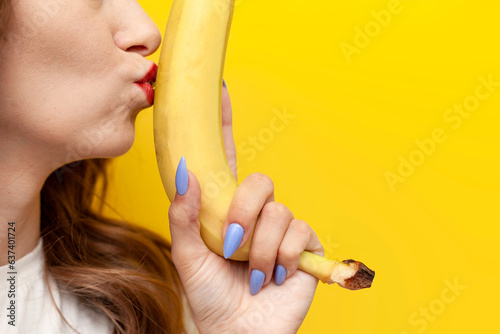 Photos young girl kisses banana and hints at intimacy on yellow background, sexy and er