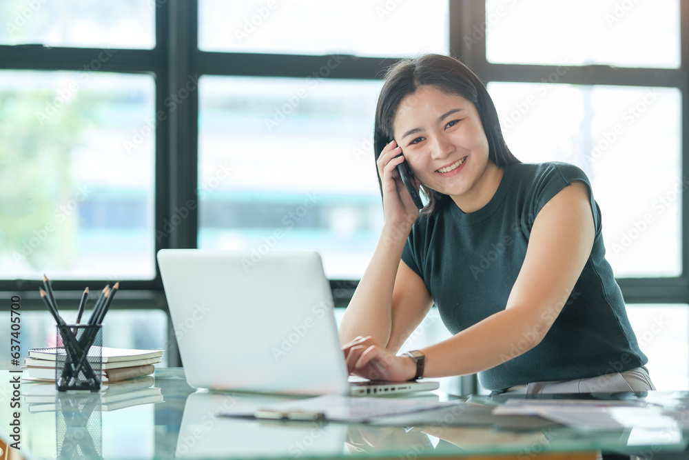 Attractive asian businesswoman talking with her business partner while sitting in modern office.