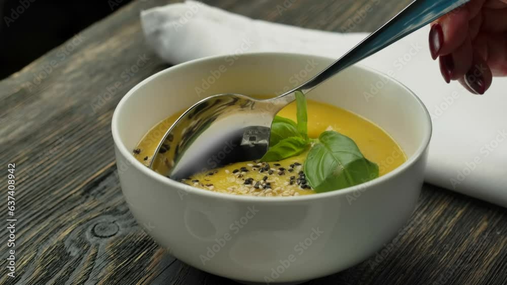 Spoon scoops soup puree with sprinkled sesame seeds Spoon scoops soup puree with sprinkled sesame seeds