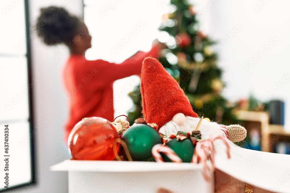 Fototapeta premium African american woman smiling confident decorating christmas tree at home