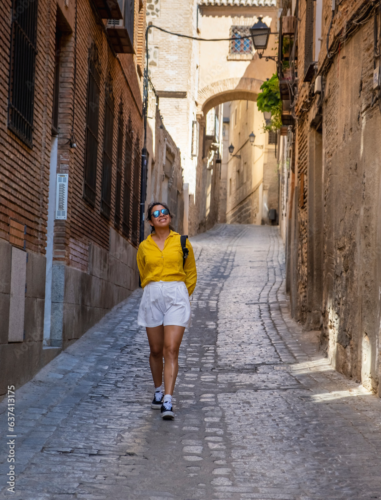 Young woman tourist enjoying and exploring the medieval city of Toledo in Spain