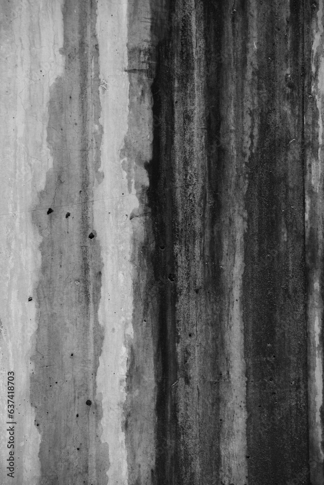 abstract black and white design of water damage on concrete cement exterior wall of building with water dripping and weathered areas  of different dampness abstract backdrop vertical lines type space