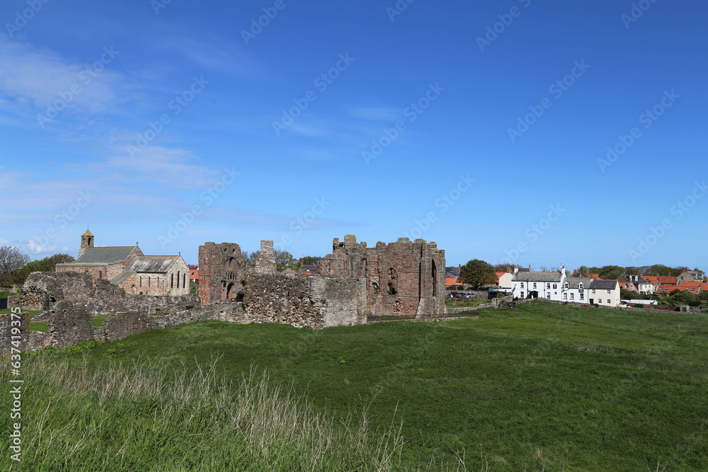 A sunny view across to St. Mary the Virgin Church and the ruins of Lindisfarne Priory on the Holy Island, Northumberland, England, UK.