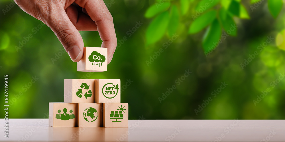 concept of carbon credit reducing carbon emissions Zero net greenhouse gas emissions target Carbon credits to invest in sustainable businesses green climate investment wooden block with green icon - obrazy, fototapety, plakaty 