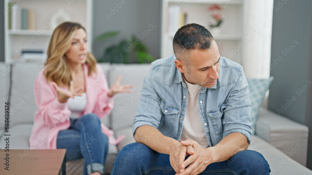 Man and woman couple sitting on sofa arguing at home Man and woman couple sitting on sofa arguing at home