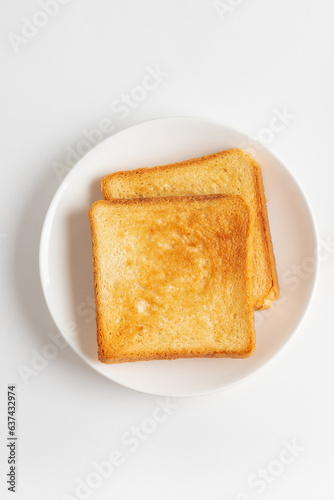 Two toasts in a white plate isolated on white background, top view