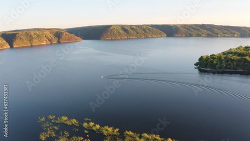 4k drone flight moving to the side footage (Ultra High Definition) of Bakotska Bay with motor boat. Amazing summer scene of Dnister river, Ukraine, Europe. Traveling concept background. photo