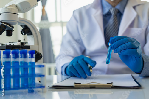 Scientists worked with a vial of indigo solution with ozone juice of the blue in a lab vial with a microscopic laboratory. Doctor Remote Image