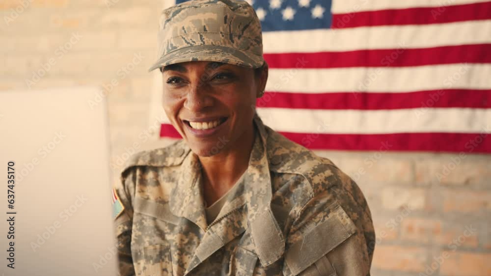 Soldier blowing kisses over a video call as she connects with her family from the military Soldier blowing kisses over a video call as she connects with her family from the military