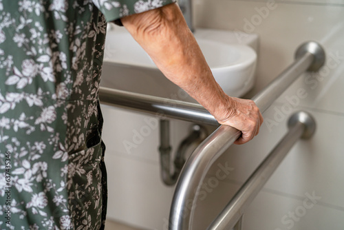 Fotografia Asian elderly woman patient use toilet bathroom handle security in nursing hospital, healthy strong medical concept