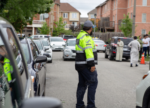 Security guard controlling traffic on busy street