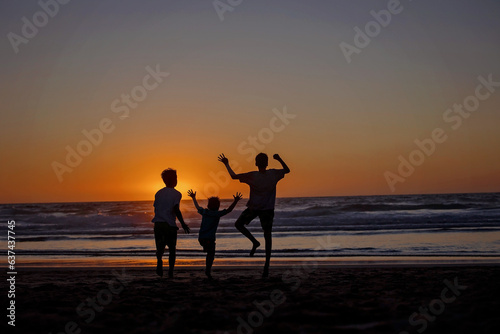 Happy children, boys, playing on the beach on sunset, kid cover in sand, smiling, laughing