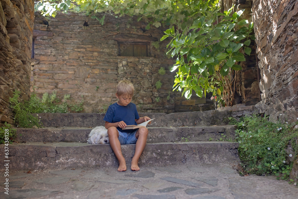 Beautiful medieval village Talasnal in Lousa, Portugal on a beautiful day. Child playing on the street of the village with his pet dog Beautiful medieval village Talasnal in Lousa, Portugal on a beautiful day. Child playing on the street of the village with his pet dog