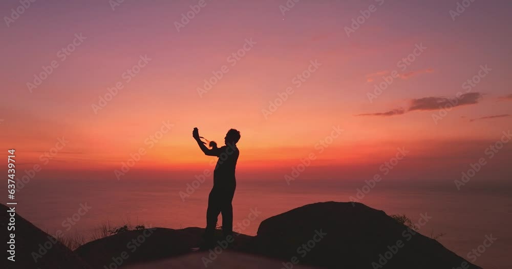 ..In a red sunset, a man takes a selfie on a cliff in bright red sky. .Nature video High quality footage. Meditation ocean and sky background. .Majestic sunset or sunrise cloudscape background.. ..In a red sunset, a man takes a selfie on a cliff in bright red sky. .Nature video High quality footage. Meditation ocean and sky background. .Majestic sunset or sunrise cloudscape background..
