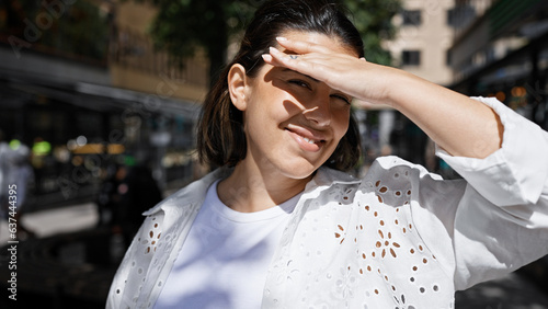 Canvas Print Beautiful young hispanic woman covering face and eyes with hand to block sunligh