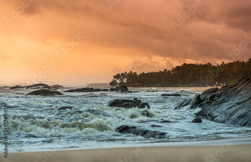Dramatic sunset beach scenery from Kannur Ezhara beach, Beautiful cloudy sky with palm trees on the background, Kerala landscape image
