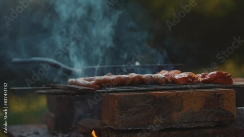 Sausages cooking on a BBQ grill, barbecue picnic outdoors barbeque smoked food, meat pork
