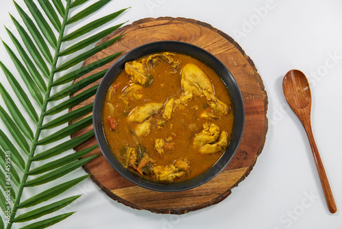 Chicken curry or masala or country chicken kuzhambu Tamilnadu style , chicken curry using fried coconut oil in traditional way and decorated in white bowl. Main dish for rice, chapati and paratha... photo