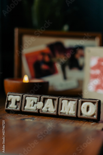 chocolate letters that say "I love you" with photos of a couple in the background