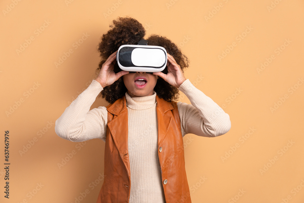 Obraz premium excited black woman Using VR headset and gesturing in all beige colors. virtual reality, technology simulation concept.