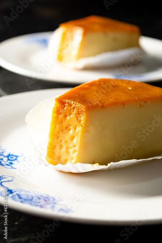 pudim or pudding slice. also known as flan. vertical shot of two slices of pudding photo