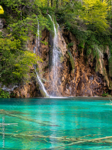 Small waterfall with azure water in Plitvice Park, Croatia. Summer time vibes, travel experience, explore nature.