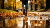 Leg of person walking in puddle in autumn