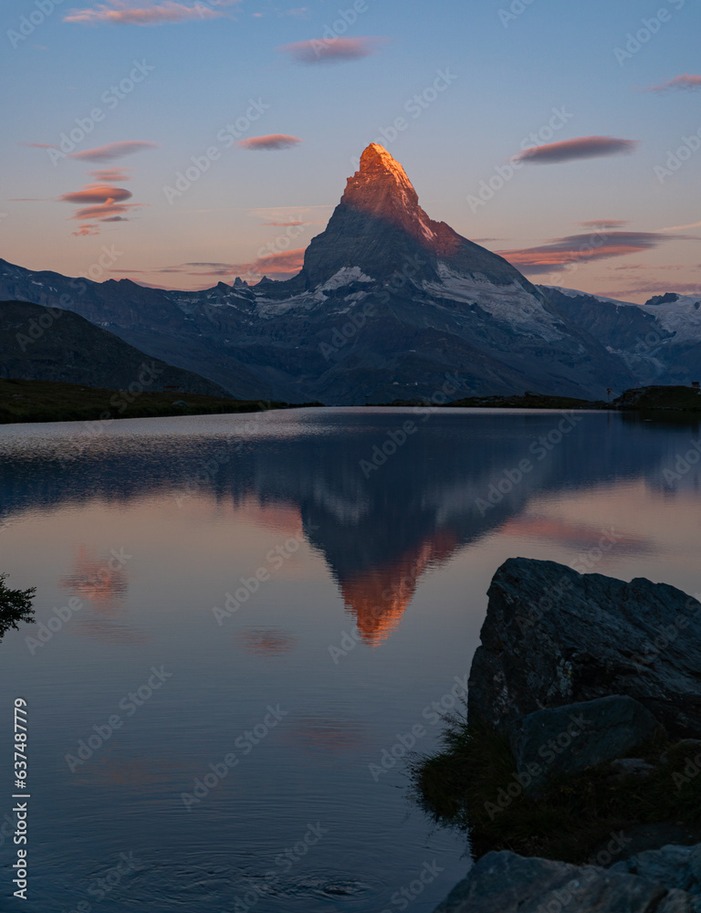 early morning view of the famous Matterhorn with beautiful colours and a burning top. View from Stellisee in Zermatt