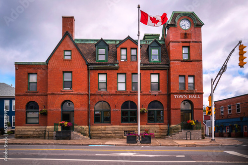 Historic red brick Antigonish Town Hall building and Canadian national Flag in Nova Scotia, Canada