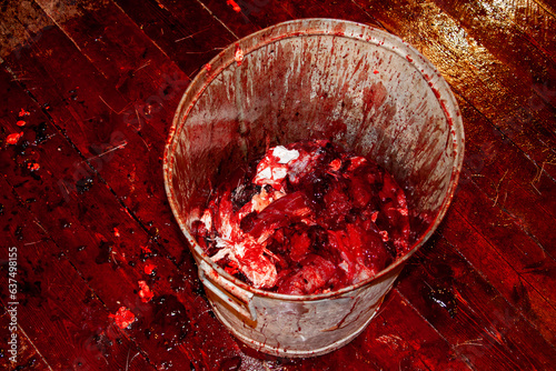 Принти на полотні Metal bucket with bloody offal and a lot of blood on the wooden floor