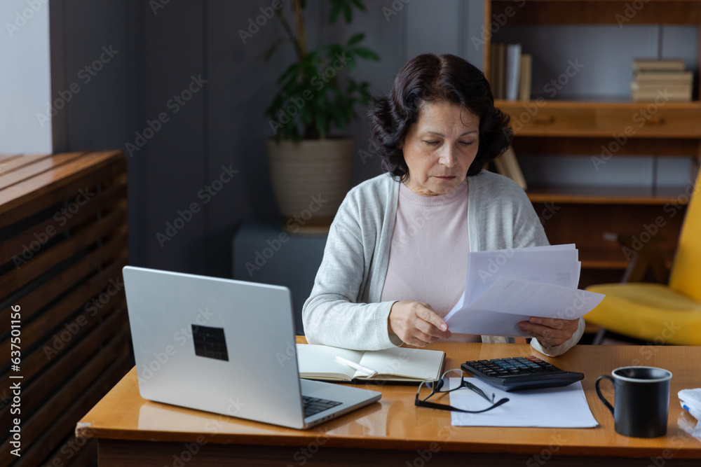 Middle aged senior woman sit with laptop and paper document, Pensive older mature lady reading paper bill pay online at home managing bank finances calculating taxes planning loan debt pension payment Middle aged senior woman sit with laptop and paper document, Pensive older mature lady reading paper bill pay online at home managing bank finances calculating taxes planning loan debt pension payment